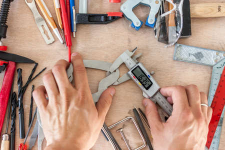 man measuting part with calipers in workshopの写真素材