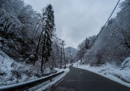 Winter dark road between mountainsの写真素材