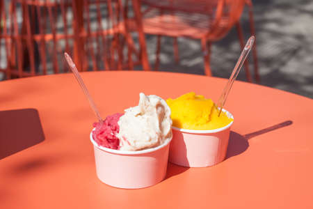ice cream in paper cups orange tableの写真素材