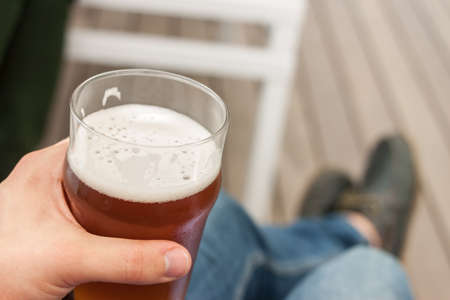 vacation concept hand with glass of beerの写真素材