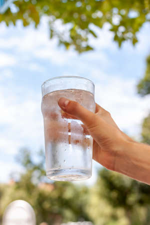 women hand holding glass of cold waterの写真素材