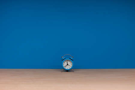 lonely blue alarm clock on paper backgroundの写真素材