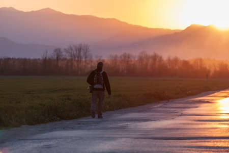 evening road heading to sunset man walking forwardの写真素材