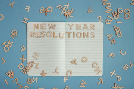 open notebook with words new year resolutions made out of wooden lettersの写真素材