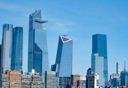 New York skyscrapers glass metal and concrete buildings against blue skyの写真素材