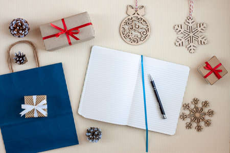 wish list with pen among christmas wrapped gifts and decorationの写真素材