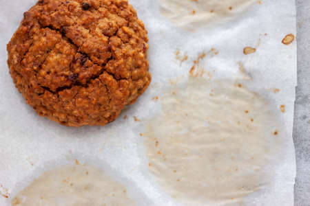 homemade baked oat cookie on white baking paper with copyspace