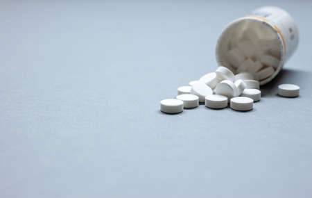 medical pills and tablets on table spilled next to bottleの写真素材