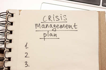 crisis management plan hand written words in notebookの写真素材