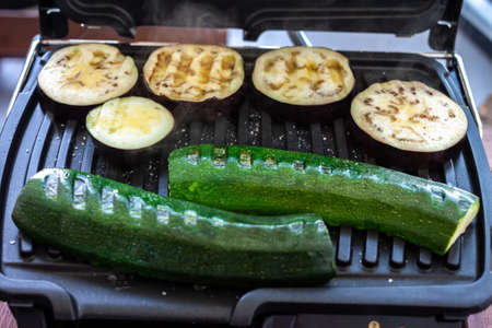 zucchini and eggplant cooking at home on electric grillの写真素材