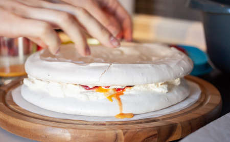 preparing cooking pavlova cake at home kitchen female handsの写真素材