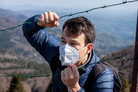 young man in protective mask and sunglasses walking outside in natureの写真素材