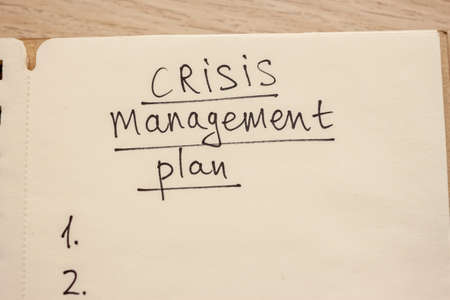 crisis management plan hand written words in notebookの写真素材