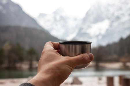 male hand keepcup walking outdoors mountain background