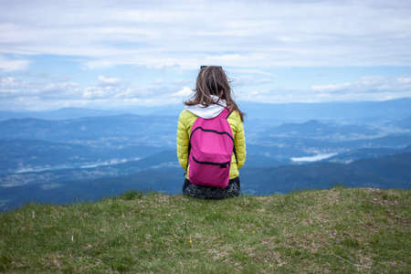 woman hiker in colorful clothes on the top enjoying the landscape viewの写真素材