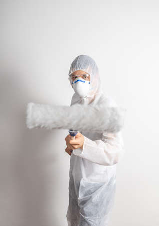 man with paint roller dressed in white protective suitの写真素材