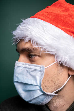 man in red santa claus hat and face mask portraitの写真素材