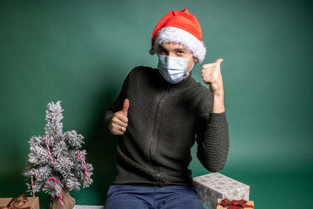 man with many wrapped gifts on green backgroundの写真素材