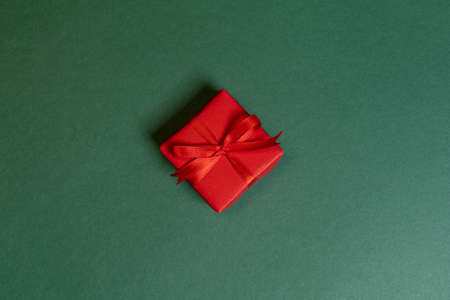 one red Christmas wrapped gift on green backgroundの写真素材