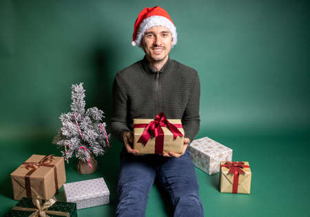 man with many wrapped gifts on green backgroundの写真素材