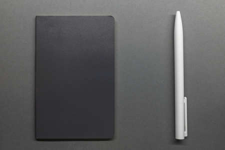 grey notebook and white pen on table flat layの写真素材