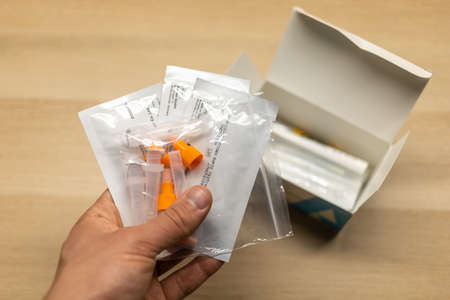 LJUBLJANA, SLOVENIA - NOVEMBER 2021: Man keeps a set of covid self-testing kitsのeditorial素材