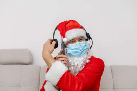 man dressed as Santa Claus in headphones