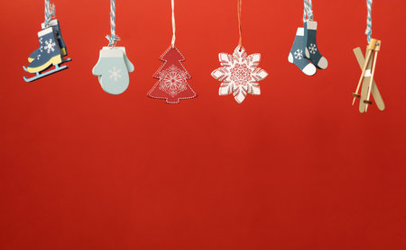 christmas decoration toys hanging over red backgroundの写真素材