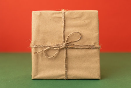 one craft wrapped gift over red backgroundの写真素材