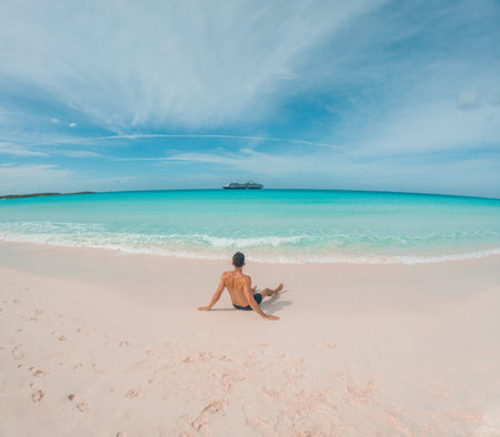 Man enjoing lounging on the ocean at Half moon cay Bahamas private island Caribbeanの写真素材