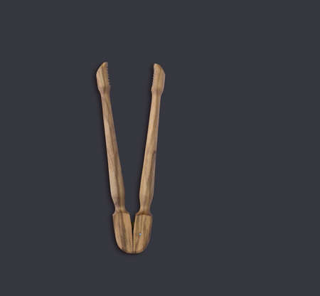 Top up view olive wooden tongs isolated on dark background. suitable for your design element.の写真素材