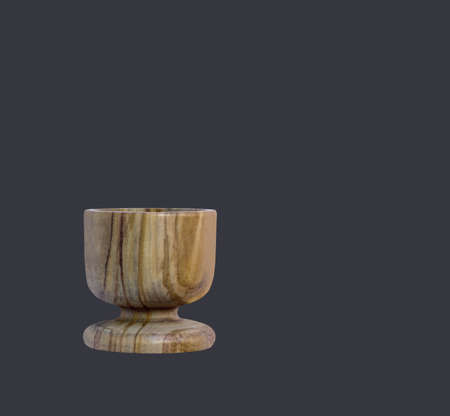 Close view olive wooden egg cups isolated on dark background.の写真素材