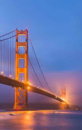 scenic view of Golden gate in the in the dusk with lighting and reflection on the water and fog,San Francisco,California,usa.の写真素材