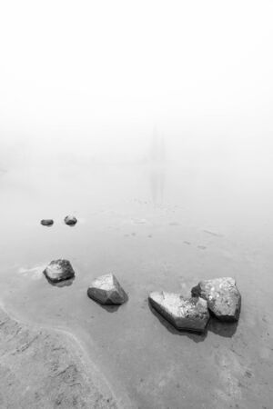 peaceful rock,rock in the lake with fog over the lake in black and white..の写真素材