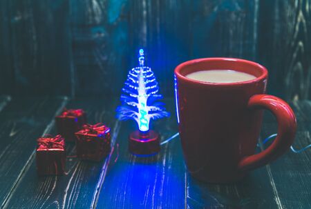 a red cup of coffee with red Christmas ornament on the dark wooden background.の写真素材