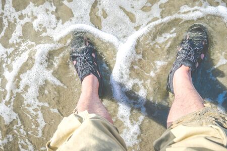 foot with water shoe on the beach.