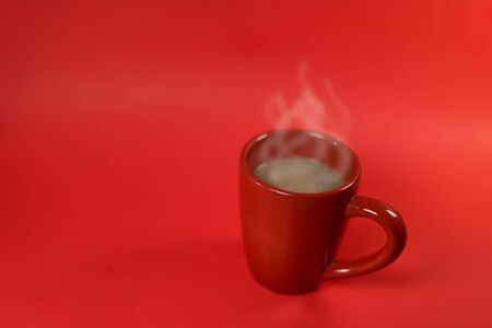 a red cup of coffee on the red background with space for product display montage..の写真素材