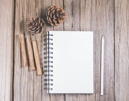 white blank space notebook with pencil and christmas ornament on the wooden top.の写真素材