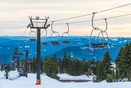 ski lift with seats going over the snow mountain in ski resort.の写真素材