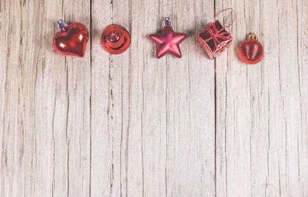 brown wooden panel with red Christmas ornament:heart,bell,star,gift box and spear,ready for product display montage.の写真素材
