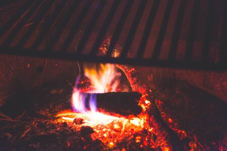 Stainless Steel BBQ Grill over bonfire im camp site in campground at night.の写真素材