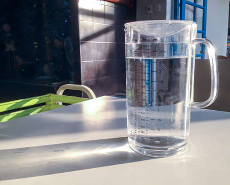 Jug of water on the white table with spectruc light