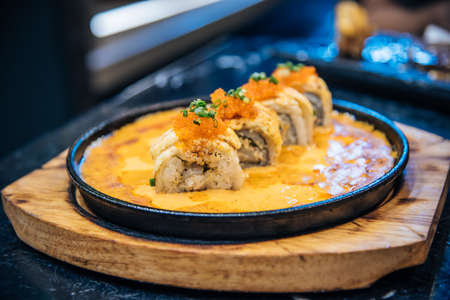 Salmon top with cheese in the hot pan with sauceの写真素材