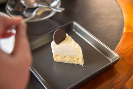 a hand going to eat dessert , Coconut cake.