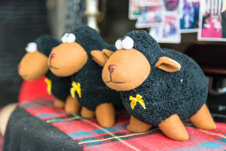Three black sheep on the table with yellow ribbon in their neck.の写真素材