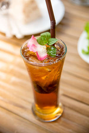 A cup of chinese tea on the wood table and decorate with rose leaf and mintの写真素材