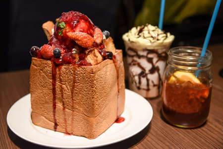 A dessert in Japanese is a strawberry honey toast with fruit jar and milk shake