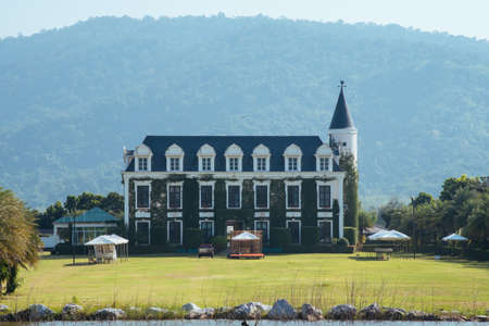 blue white castle english style with garden and tree on blue sky backgroundのeditorial素材