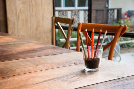 Multi-colored pencils and rulers in wooden pots on wooden boards.の写真素材