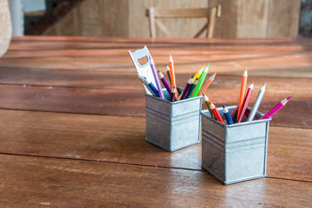 Multi-colored pencils and rulers in wooden pots on wooden boards.の写真素材